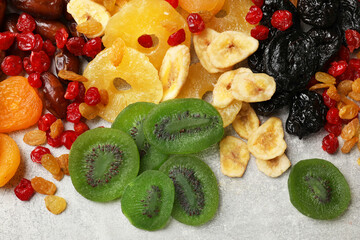 Mix of different dried fruits on grey table, top view