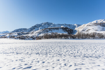 Bright sunny winter day in the mountains. Blue sky and snowy peaks. Winter travel.