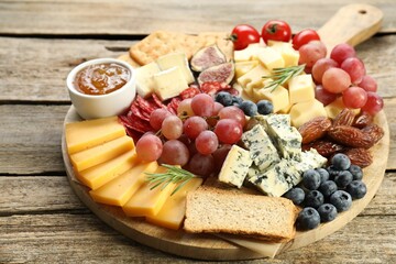Different types of delicious cheese and other snacks on wooden table, closeup