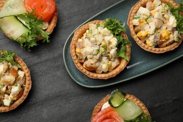 Tartlets with delicious fillings on black table, top view