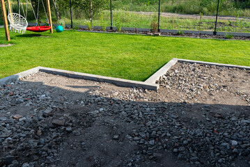Compacting rubble on a terrace under construction using a gasoline powered hand held compactor.
