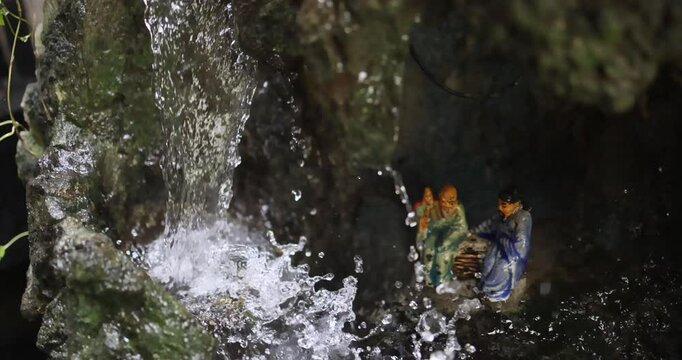 Asian deities in a Vietnamese temple under a mini waterfall.