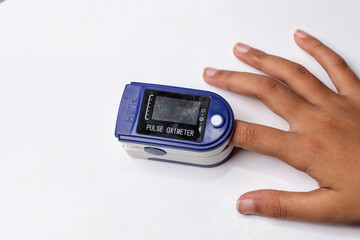 A hand using a fingertip pulse oximeter isolated on white background