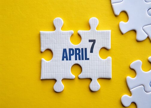 April 7th Calendar Date on White Jigsaw Puzzle Pieces - Yellow Background