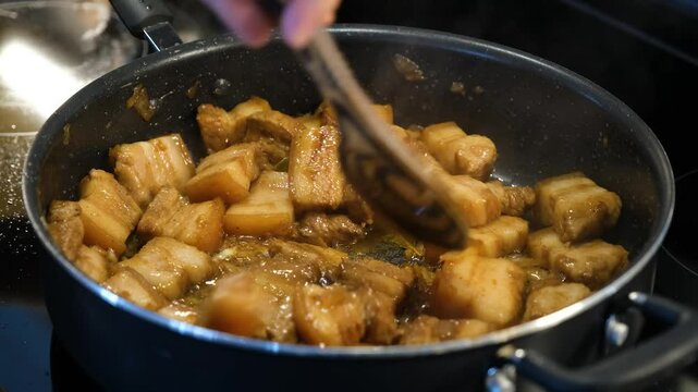 Cooking delicious Filipino adobo with succulent pork and flavorful sauce