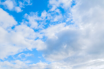Fototapeta premium Blue sky landscape with scattered white clouds. Soft fluffy formations under bright daylight
