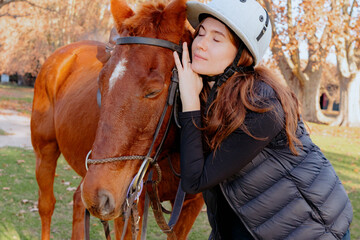 Young woman with horse on the field on autumn