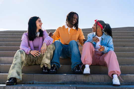Multiethnic group of young hip hop dancers wearing colorful streetwear dancing outdoors - Stylish multiracial rap crew members meeting and having fun together