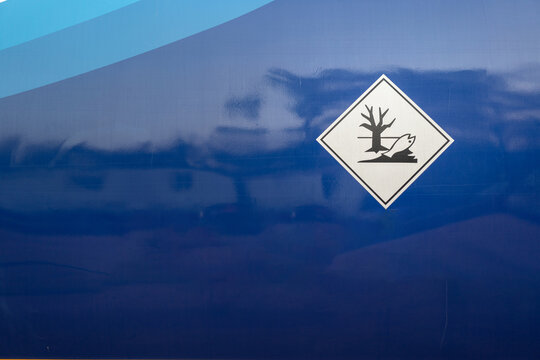 Enviromental impact placard sign of dealth biology picture, that installaed on the storage tank of the chemical road tanker vehicle. Safety sign and symbol for transportation. Selective focus.