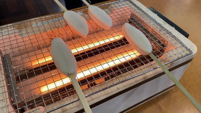 Tourists Grilling Sasa-kamaboko (Fish Cake). Grilling Sasa-kamaboko is a popular activity for tourists visiting Matsushima. Sasa-kamaboko is a local specialty from Miyagi Prefecture, Japan.