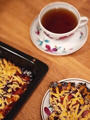 Enjoying a warm slice of homemade dessert paired with a freshly brewed cup of tea on a cozy wooden table