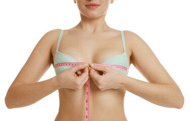 Woman in beautiful bra measuring breast circumference on white background, closeup