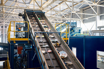 Rubbish on conveyor belt in recycling plant workshop