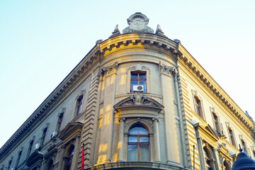 Fototapeta premium Sights in Belgrade city center: upper part of the corner facade of the historical building of the National Bank on King Petar Street. Architecture in Serbia: large old building with decoration.