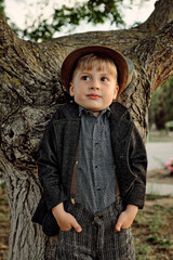 the child against the background of the tree shows confusion