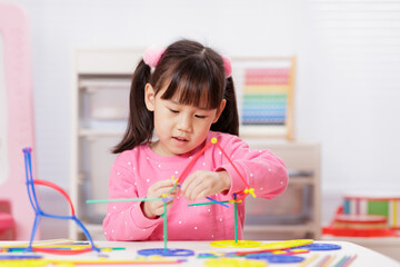 A young girl engages in creative construction toys at home