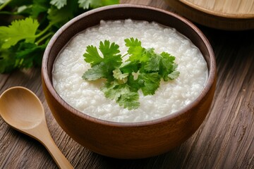 Rice porridge in bowl, topped with cilantro, on wood, for health and nutrition