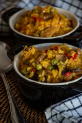 homemade dish of paella with vegetables in small casserole dish