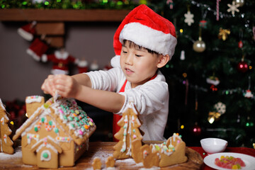 little girl decorating ginger bread House for celebrating Christmas at home