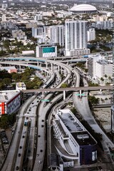 Fototapeta premium High angle aerial cityscape view of downtown multi lane highways a river channel and transit bridges