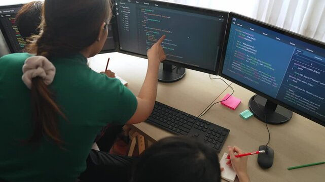 Slow motion back end software developer engineer for computer programming working together on debugging writing computing code, solving complex algorithms display on monitor in office. Burgeoning