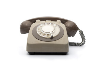 A classic vintage rotary telephone with a brown and beige color scheme, placed against a white background. This nostalgic communication device represents timeless elegance and retro aesthetics.