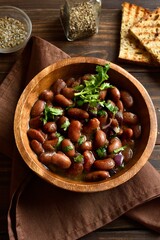 Baked beans in bowl on wooden table