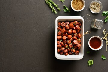 Sweet and spicy sausage bites in baking dish