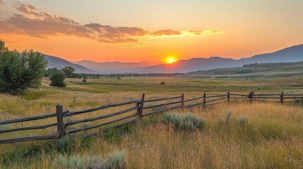 Fototapeta premium A stunning sunset over rolling hills, casting golden hues across the meadow and wooden fence, creating a tranquil ambiance in nature's embrace.