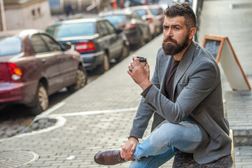 Man drinking morning coffee. Coffee break. Everyday style routine. Bearded man having coffee in city street. Handsome man on street holding cup of coffee. Business lifestyle, break. Relax outdoor