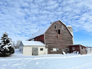 Great holiday picture - old wood barn, blue sky with interesting cloud texture, and snow cover