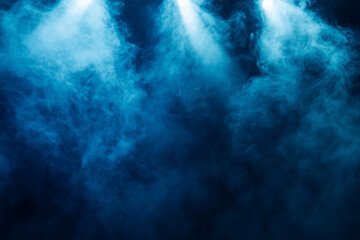 Fototapeta premium A dramatic scene featuring blue smoke illuminated by bright stage lights, creating a moody and atmospheric effect. Perfect for use in designs related to music events, performances, or creative project