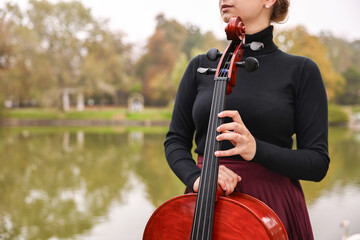 Young woman with cello in park, closeup. Space for text © New Africa