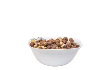 A white bowl decorated filled with roasted hazelnuts, some with peels and others peeled. Close-up...