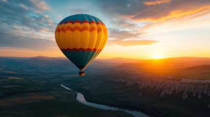 Fototapeta premium A vibrant hot air balloon floats gracefully in the sunset sky, showcasing a stunning view of the lush landscape and winding river below, evoking a sense of adventure and tranquility.