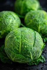 Fototapeta premium Fresh green cabbage with water droplets on dark surface