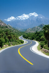 Fototapeta premium Winding road leads to snow-capped mountain on a sunny day for travel, tourism