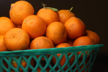 Fresh small oranges in plastic basket