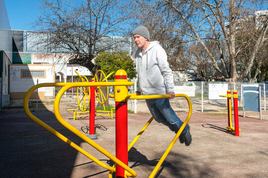 man using bars in outdoor gym, push up exercises