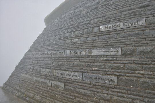 Wales, Gwynedd, Snowdonia - July 09, 2024: The way to the summit is indicated on the stone wall at the Hafod Eryri visitor center. 