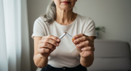 Stop smoking cigarettes concept. Portrait of beautiful smiling girl holding broken cigarette in hands. Happy female quitting smoking cigarettes. Quit bad habit, health care concept. No smoking.
