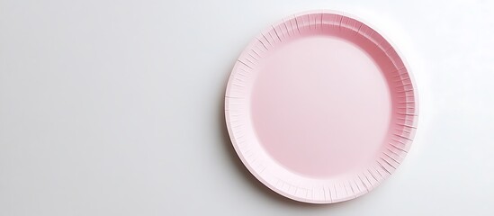 Soft pink paper plate on a pristine white surface, top view photography.