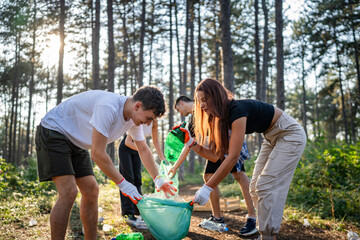 teenage friends young men women pick up waste garbage to clean forest