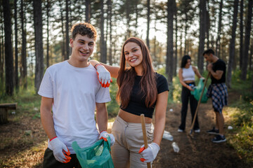 portrait couple in front of group of friends volunteers prepare to collect garbage waste and clean...