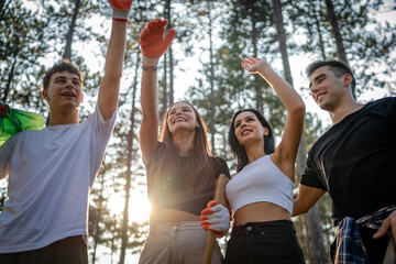 teenage friends young men women pick up waste garbage to clean forest