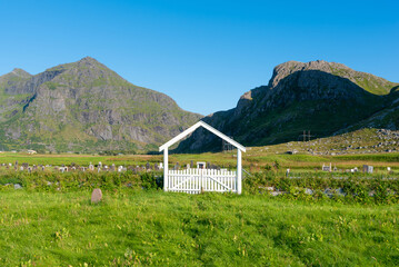 ..Entrance gate to the Old Cemetery of Flakstad. In the background, among other things, the peaks of the Blekktinden and Digertinden mountains. Lofoten District in Norway