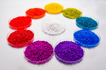 Various colors of masterbatch granules in petri dish isolated on white background,color pigment carrier polymer in plastic industry.Perfect for plastic company catalog design