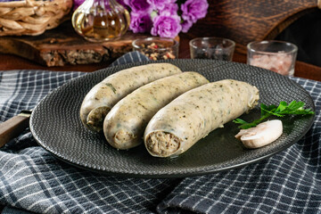Three cooked white sausages on a plate.