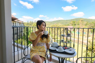 Young woman enjoyingtea on balcony with scenic view of nature