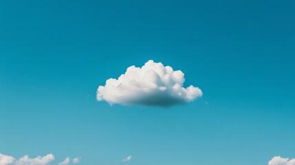 Single cloud against vibrant blue sky.  Possible use stock photo for nature, weather, or inspirational themes